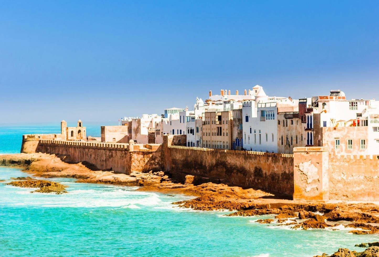 Essaouira coastal city with white and blue buildings by the sea with turquoise water